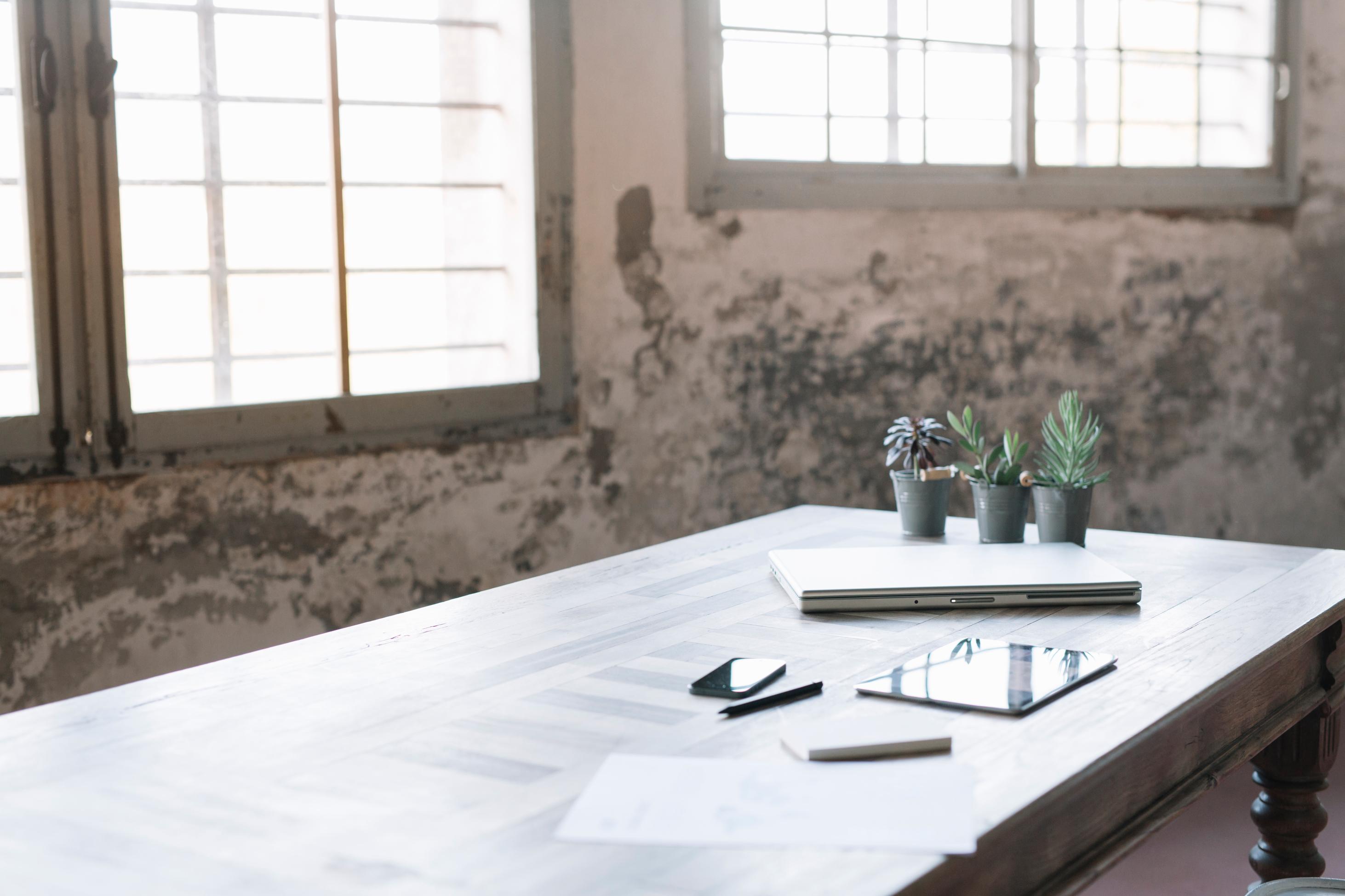 Industrial Office Space With Plants And Electronics On Table